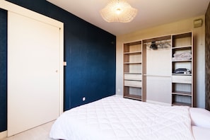 A bedroom with a bed, a wardrobe, and a hanging light fixture. - La Bisquine Granvillaise - Appt 1 chambre proche de la plage (Granville)