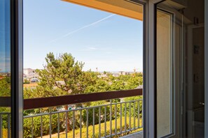 A balcony with a view of a residential area, including houses and trees. - La Bisquine Granvillaise - Appt 1 chambre proche de la plage (Granville)