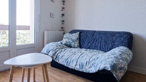 Een kamer met een bank, een klein tafeltje en een raam.