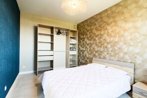 A bedroom with a bed, a wardrobe, and a nightstand. - La Bisquine Granvillaise - Appt 1 chambre proche de la plage (Granville)