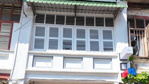 A two-story building with a sign for 'MUNTRI inn' at the entrance. - Muntri Inn by Soft Loft (George Town)