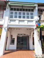 Un edificio de dos pisos con un letrero que dice 'MUNTRI inn' en la entrada.