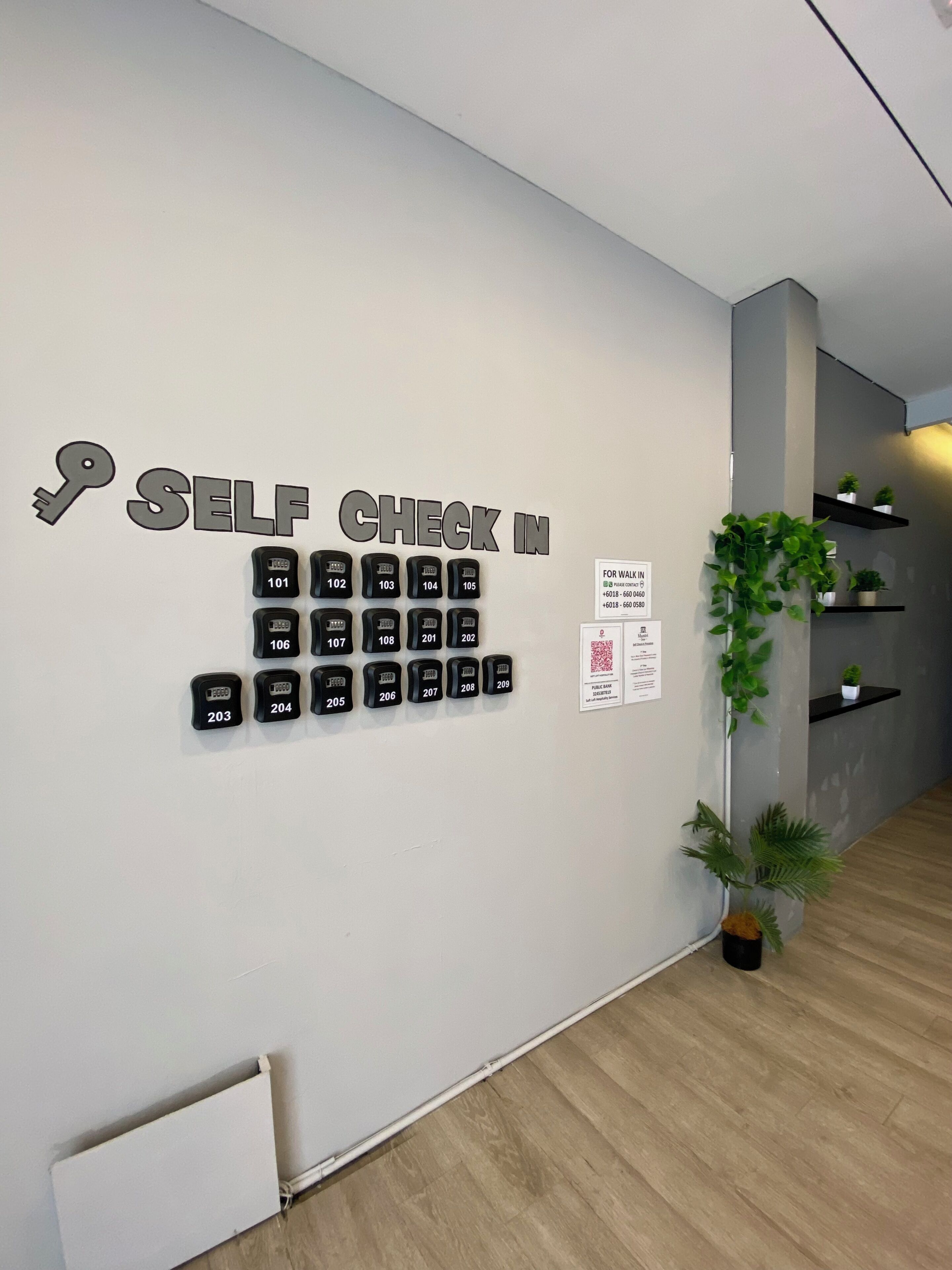 A wall with a self-check-in system and a QR code for walk-in guests.