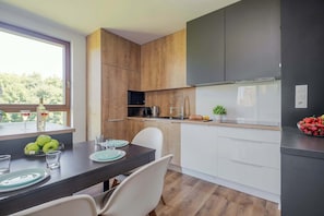 Eine moderne Küche mit Holzausstattung, einer eingebauten Mikrowelle und einer Spüle aus Edelstahl.