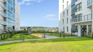 Ein moderner Gebäudekomplex mit einem zentralen Innenhof, der einen Spielplatz und eine Aussichtsplattform bietet.