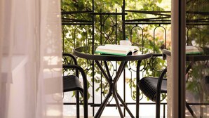 Een balkon met een tafel, stoelen, een boek en een kop.