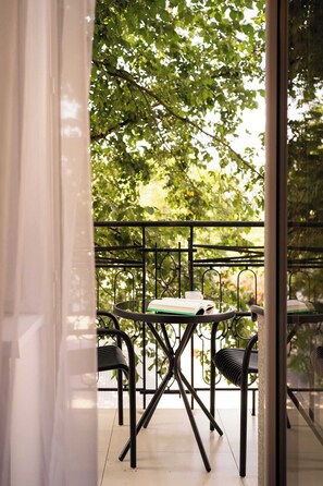 Ein Balkon mit Tisch, Stühlen, einem Buch und einer Tasse.