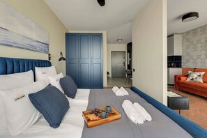 A hotel room with a bed, a sofa, a dining area, and a bathroom. - Chlebova 4.19 | Motława River & Shipyard | Gym (Gdańsk)