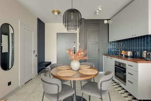 Eine moderne Küche mit grauen Schränken, einem Holztisch und einer Pendelleuchte.