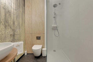 Un bagno moderno con una vasca freestanding, un water e un lavabo.