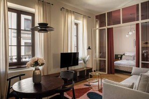 A modern living room with a television, a dining table, and a sofa. - Soho Residence 5 Boutique | Near Old Town (Kraków)