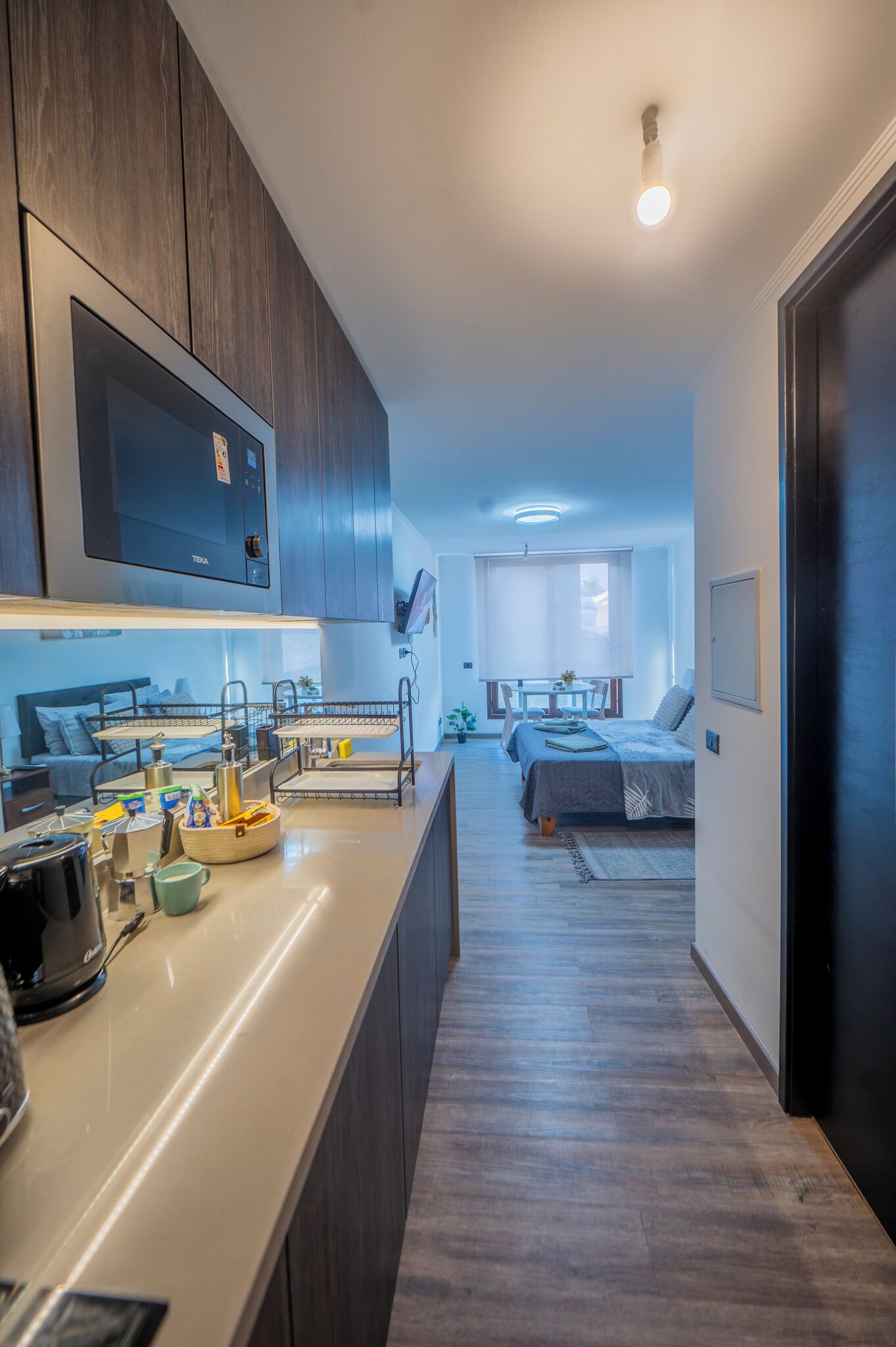 A modern kitchen with a built-in oven, a coffee maker, and a sink.