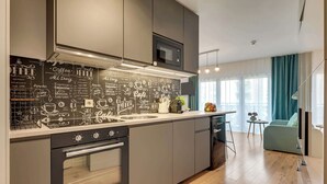 Una cocina moderna con una pared de pizarra que enumera opciones de café, un horno empotrado y un microondas.