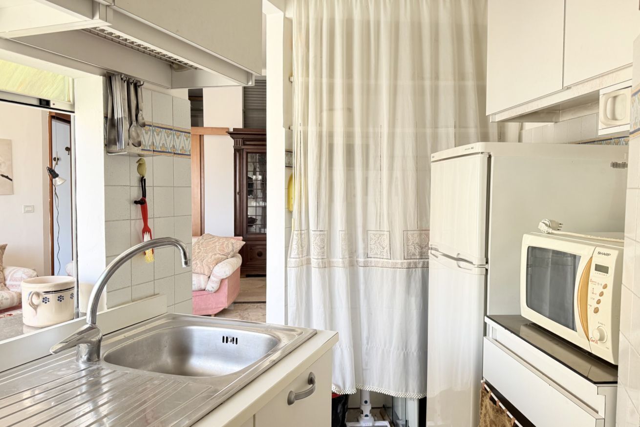 A kitchen with a sink, a microwave, and a refrigerator.
