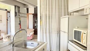 A kitchen with a sink, a microwave, and a refrigerator.