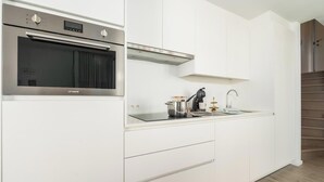 Een moderne keuken met een inbouwoven, roestvrijstalen apparatuur en een minimalistisch design.