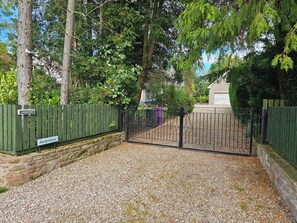 A gated entrance with a stone wall and a gravel path leading to a building. - Quiet 1-Bed Apartment | Free Parking, Fast Wi-Fi | Ideal for Contractors (Northmuir)