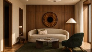A modern living room with a sofa, a round coffee table, and a green armchair. - Casa Aroa Hotel (Barcelona)