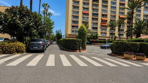 A multi-story hotel with balconies, a pedestrian crossing, and parked cars. - La Roca Sea Breeze (Torremolinos)