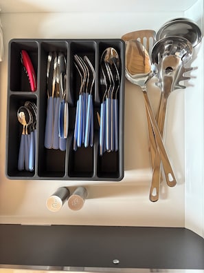 Un organizador de utensilios de cocina con compartimentos para varios utensilios.