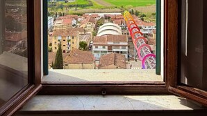 Ein Fenster mit Blick auf eine Stadt, darunter Gebäude und ein grünes Feld.