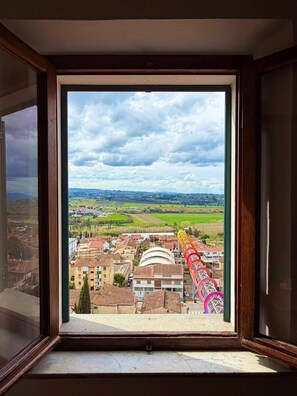 Una ventana con vistas a un pueblo, incluyendo edificios y un campo verde.