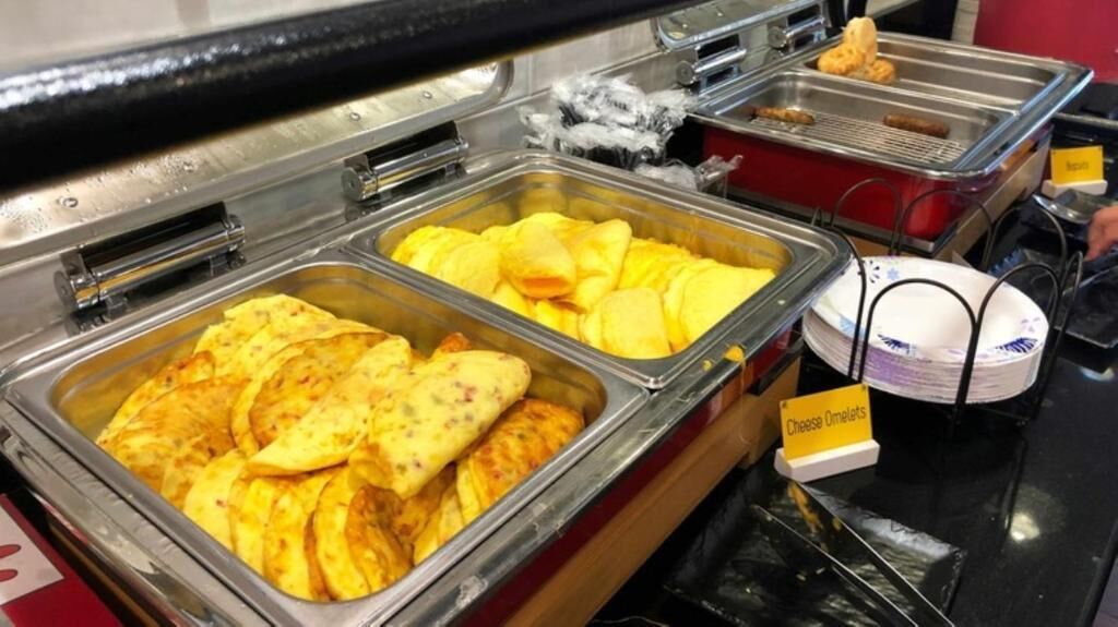 Een buffet met diverse keuzes, waaronder omeletten en tortilla's.