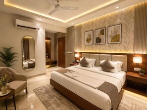 A modern bedroom with a large bed, bedside tables, a mirror, and artwork on the wall. - NH Skye Suites Hotel T-3 Delhi Airport  (New Delhi)