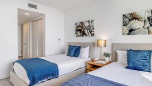 A hotel room with two beds, a nightstand, a lamp, and artwork on the wall. - Upper Studio Intracoastal & Poolside restaurant (Hallandale Beach)