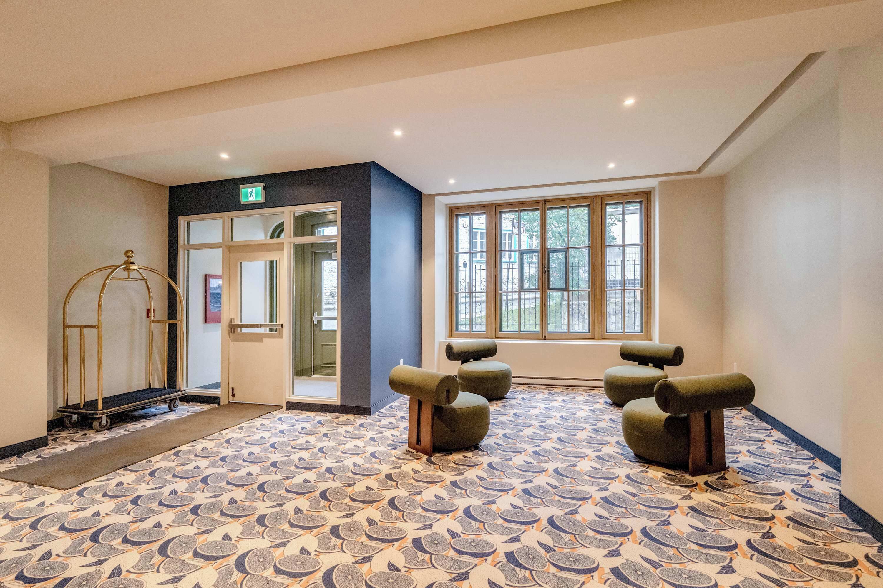 Een hotel lobby met een patroon vloer, een receptiebalie en een groot raam met uitzicht.
