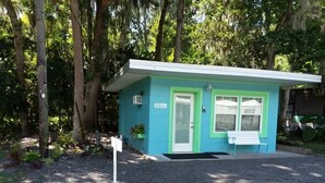 A small, single-story building with a light blue exterior and a white door.