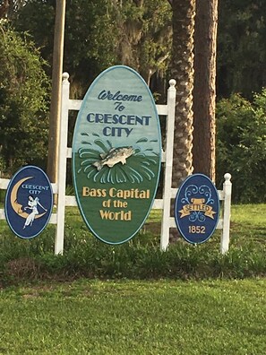 A welcome sign for Crescent City, highlighting it as the Bass Capital of the World, with a historical marker from 1852.