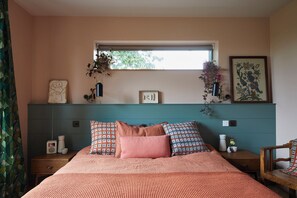 Ein Schlafzimmer mit einem Bett, einem Fenster, einer Wandregal mit Dekoration und einem Nachttisch.