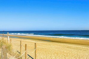 A beach with a wooden fence and rope barrier. - Sunset Pointe 302 - Pool, Prime Location (Ocean City)