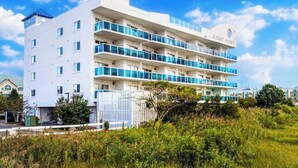A multi-story hotel with balconies, a flat roof, and a sign reading 'SUNSET POINTE'. - Sunset Pointe 302 - Pool, Prime Location (Ocean City)