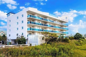 A multi-story hotel with balconies, a flat roof, and a sign reading 'SUNSET POINTE'. - Sunset Pointe 302 - Pool, Prime Location (Ocean City)
