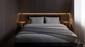 Una camera da letto moderna con un letto grande, due comodini e un soffitto spiovente.