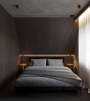 Ein modernes Schlafzimmer mit einem großen Bett, zwei Nachttischen und einer schrägen Decke.