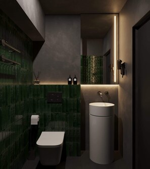 Un baño moderno con inodoro, lavabo y paredes de azulejos verdes.