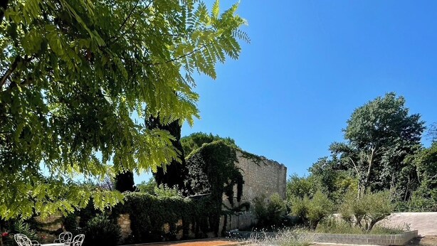 A swimming pool surrounded by gravel, with a stone wall and greenery in the background. - 90-square-meter air-conditioned vacation rental / Pool & Garden / Near the beaches (Fleury)