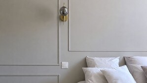 A bedroom with a bed, bedside table, and a wall-mounted light fixture. - 90-square-meter air-conditioned vacation rental / Pool & Garden / Near the beaches (Fleury)