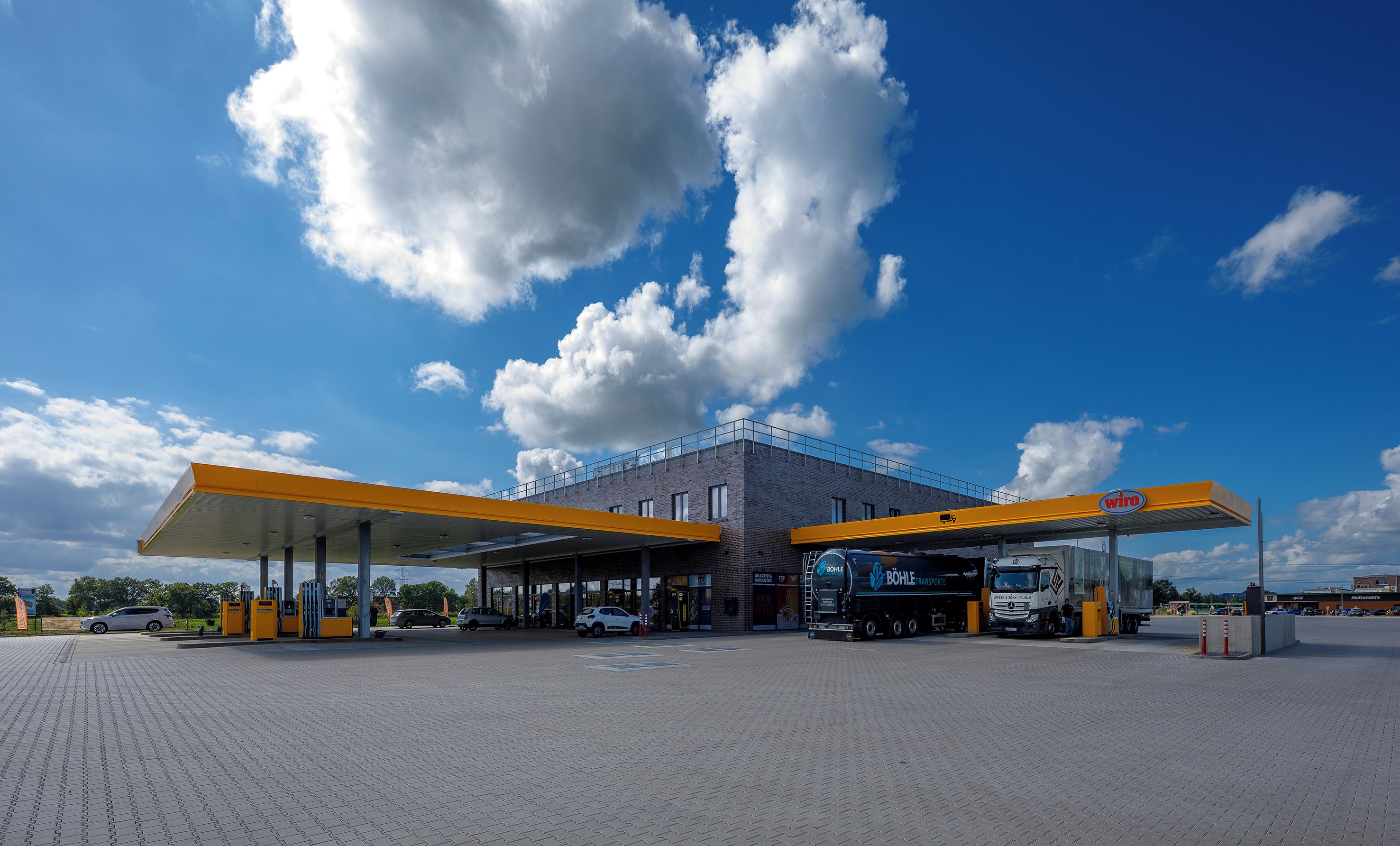 A gas station with a clear sky and clouds.