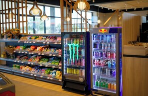 A refrigerated display with snacks and beverages, including Monster energy drinks.