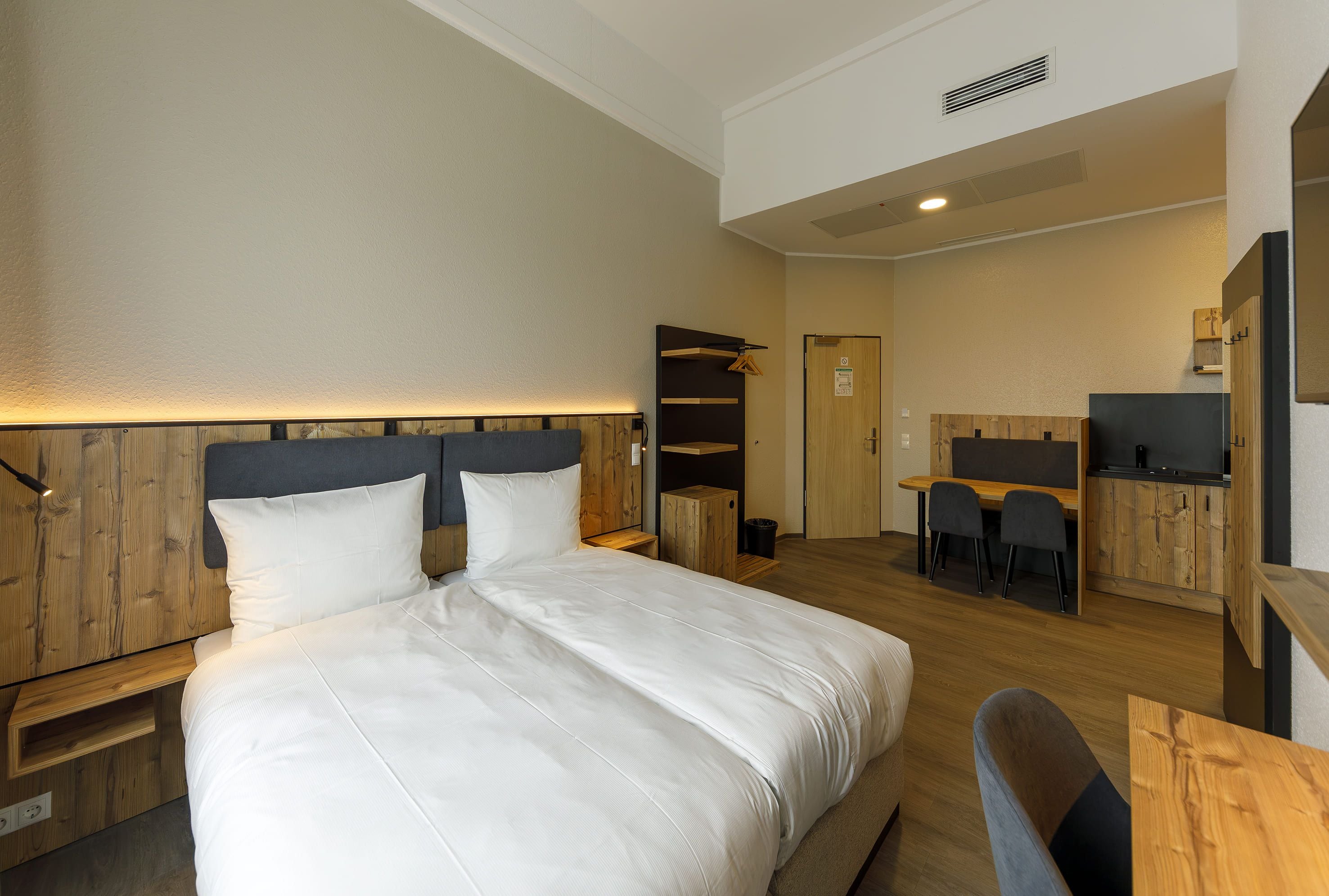 Una habitación de hotel con una cama grande, un escritorio y una silla.