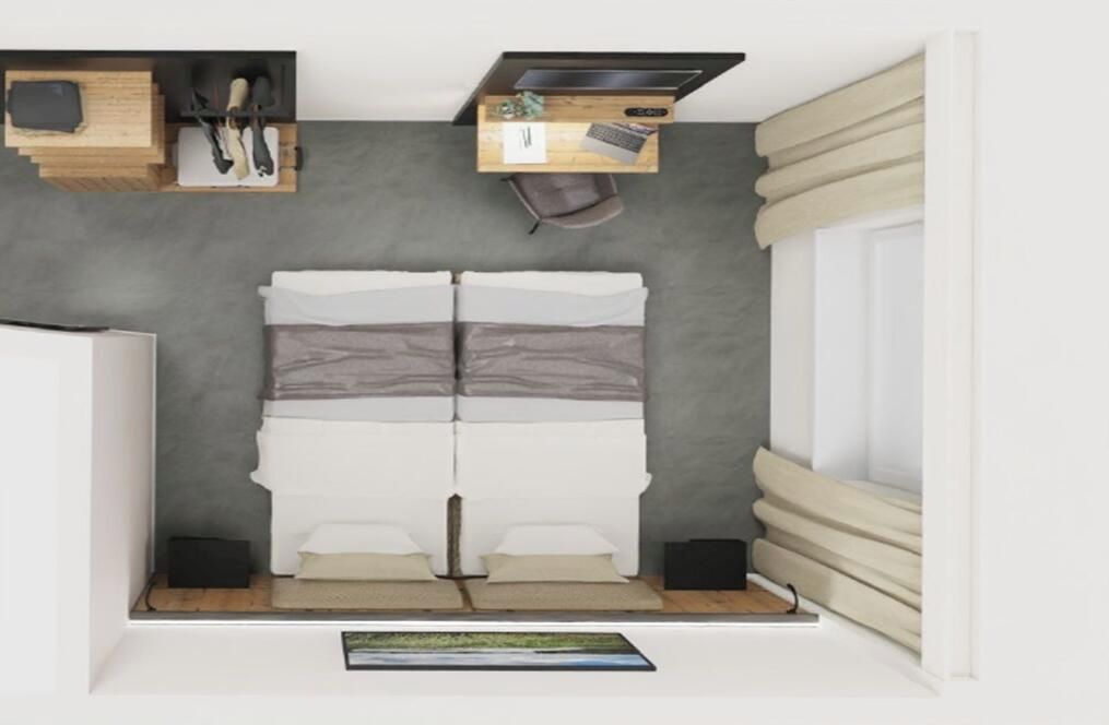 Un dormitorio pequeño con cama, un escritorio y una ventana con cortinas.