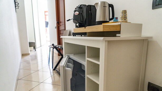 Une petite cuisine équipée d’une machine à café, d’un grille-pain et d’un petit placard.