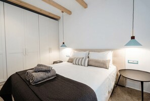 A bedroom with a bed, bedside tables, a wardrobe, and hanging lights. - Phos Chora - Six Bedroom Villa, Sleeps 12 (Mykonos)