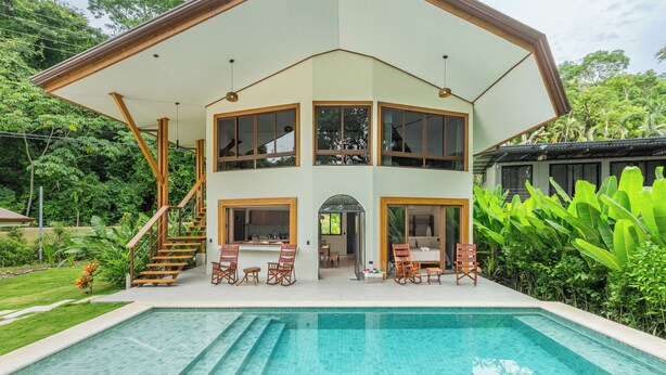 A two-story house with a large balcony, a swimming pool, and a staircase leading to the upper floor. - Relaxing Beachfront vacation in Costa Rica with a pool, overlooking the ocean! (Puntarenas Province)
