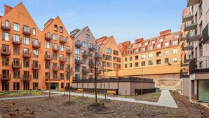 A residential building complex with multiple apartment buildings, a central courtyard with pathways, and a small park area. - Granaria B209B | Jacuzzi | Best Location (Gdańsk)