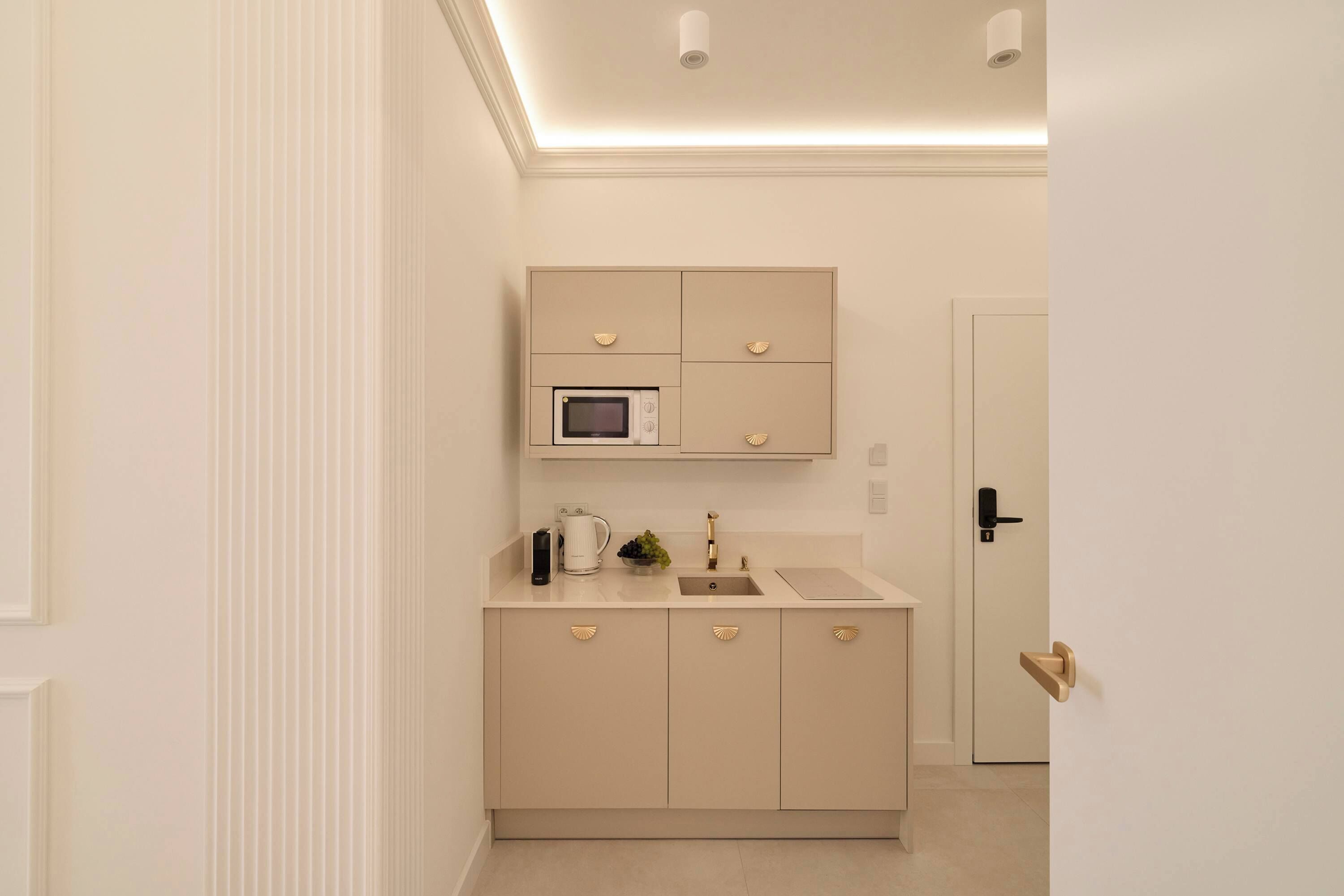 A compact kitchen with a microwave, a coffee maker, and a sink.